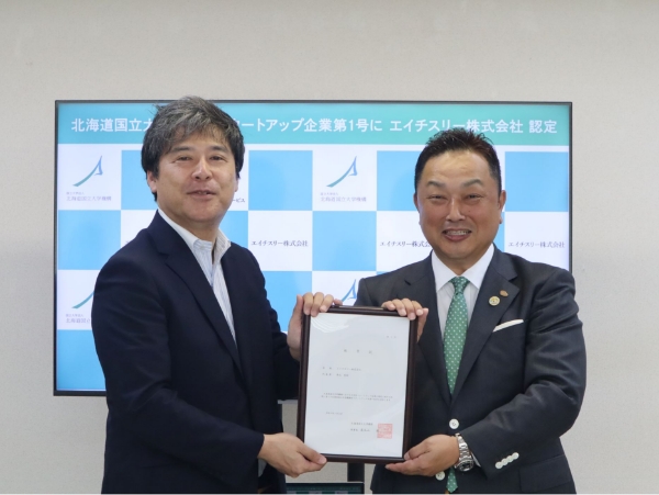 称号記を授受する岸本教授（小樽商科大学）と中元 秀昭社長(エイチスリー株式会社)